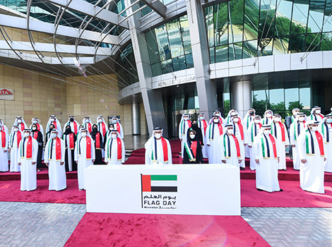 an image of Al Tayer amid employees during the hoisting of the flag